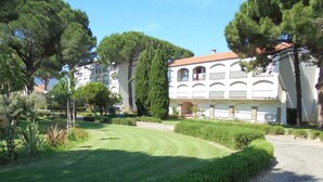 A building with a white facade, arched windows, and a red-tiled roof. - 3-room apartment, 7/8 ppl, parking, near beach (Argelès-sur-Mer)
