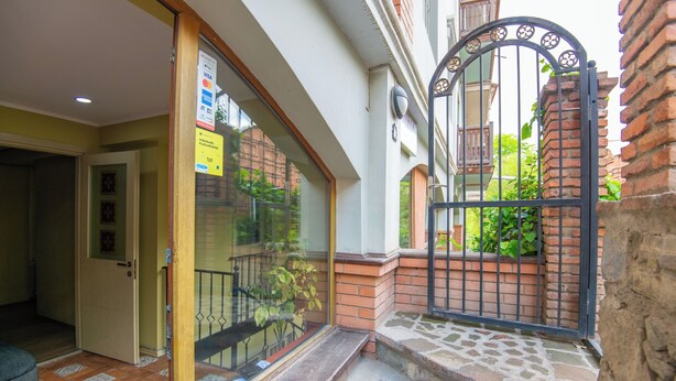 L’entrée d’un hôtel, avec une porte en verre, un portail en métal et un escalier menant à l’entrée.