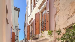 A narrow alleyway with buildings on either side, a clear blue sky, and a sign on the right building. - Vetus Oppidum Guesthouse (Chania)