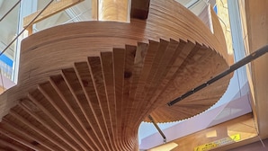 A spiral staircase with wooden steps and metal railings. - Vetus Oppidum Guesthouse (Chania)