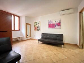 Relax in this stylish living area with a sofa, bench, and artworks on the wall.
