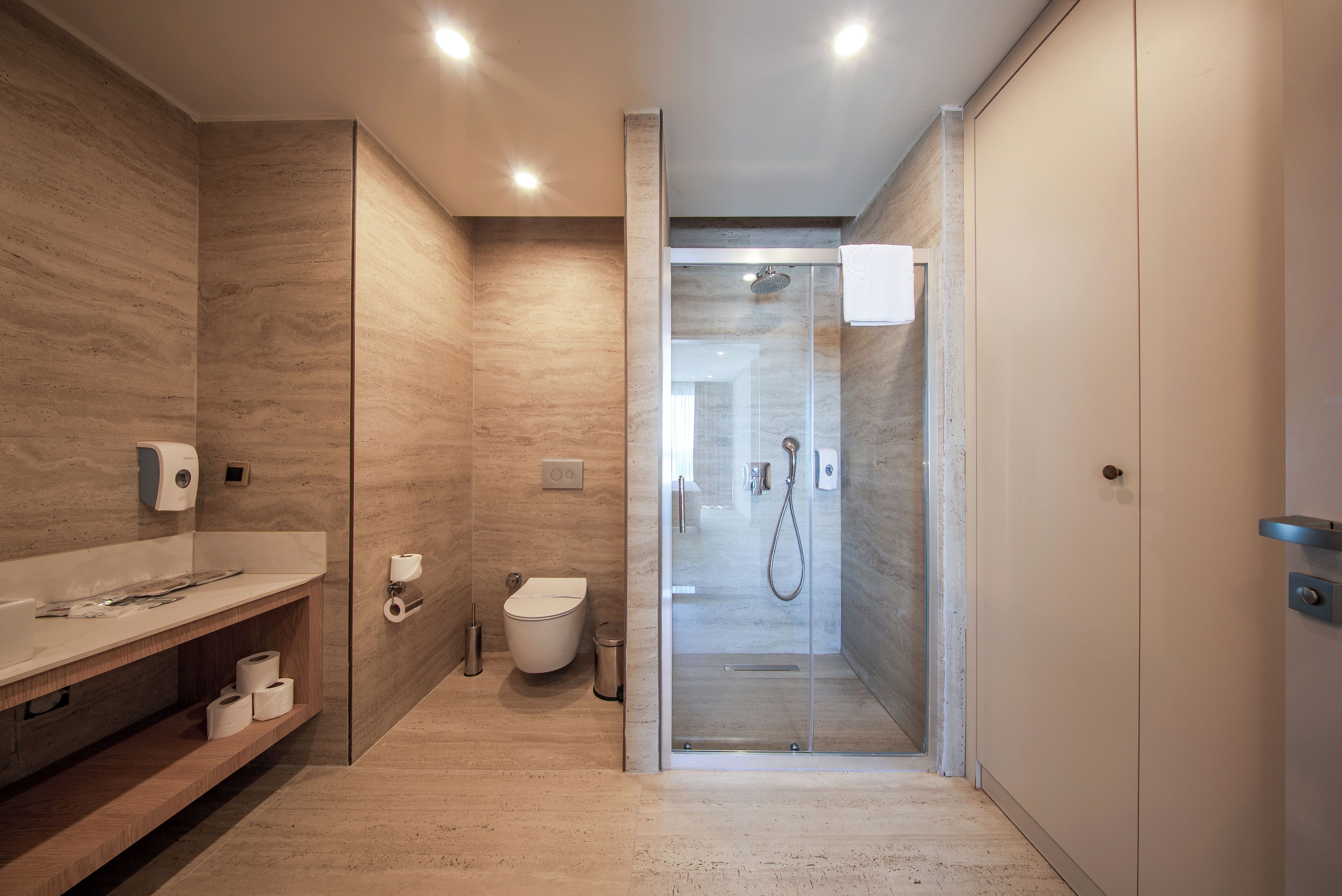 A modern bathroom with a shower, toilet, and sink.