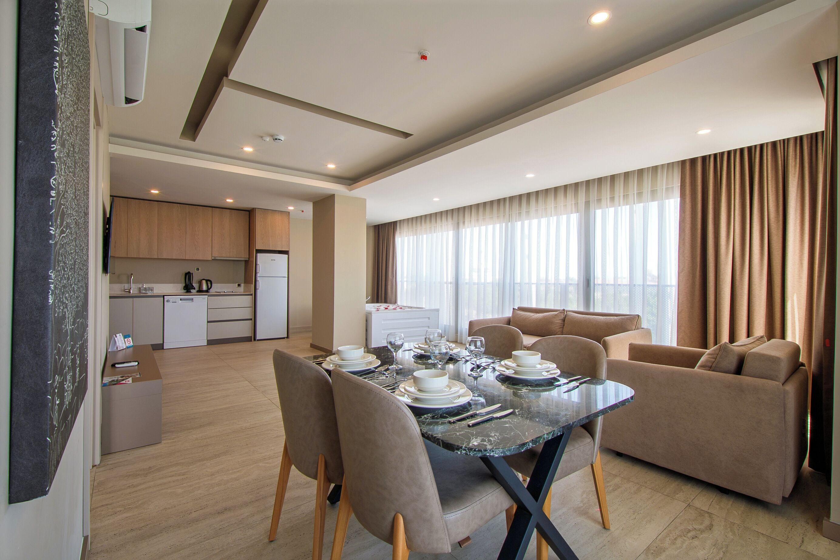 A modern living space with a dining area, kitchen, and seating area.