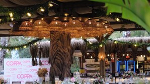 An outdoor dining area with wicker chairs, tables set with white tablecloths, and a large tree trunk centerpiece. - Prive Suite Side & Spa Hotel - Adults Only 16 Plus (Manavgat)