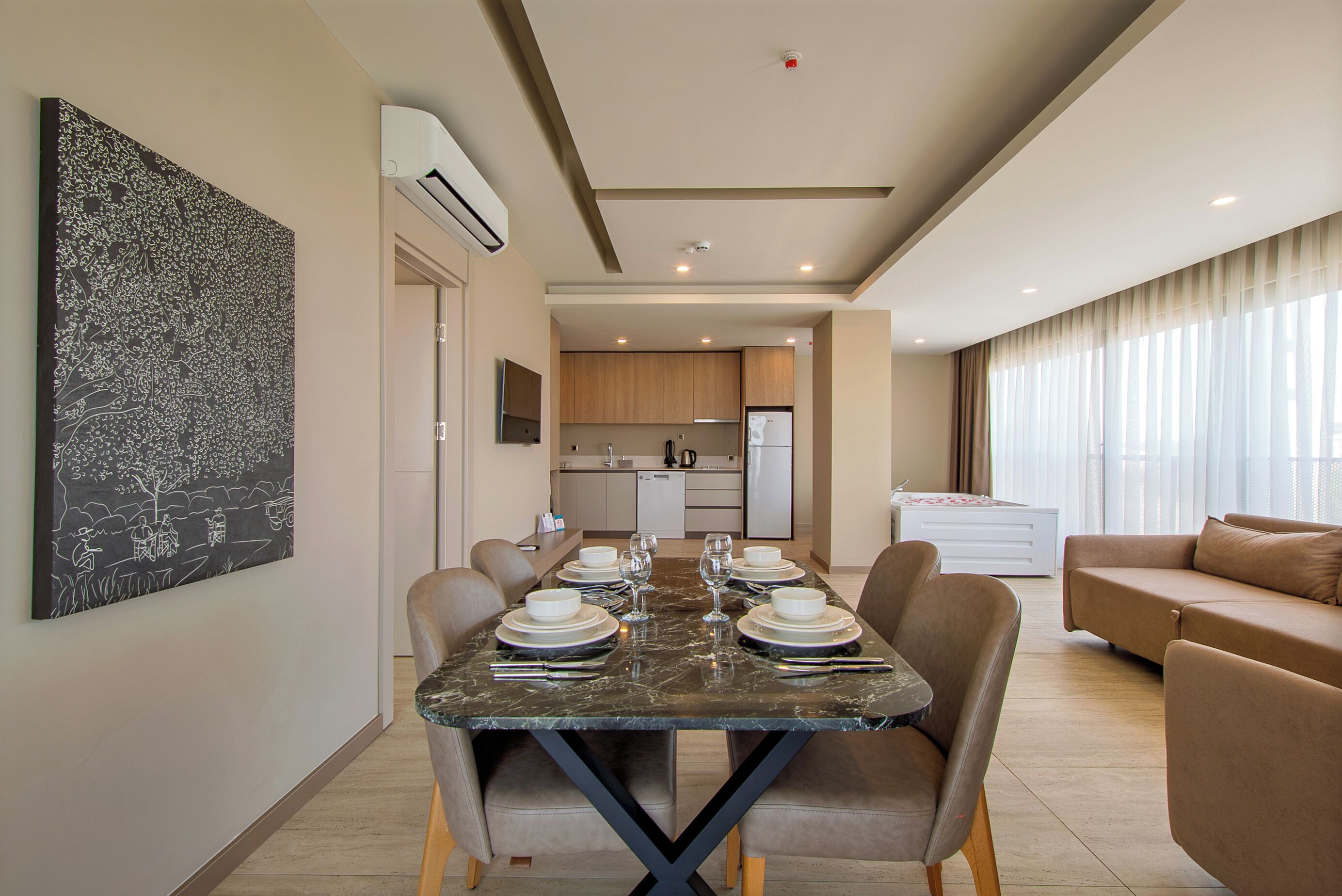A modern living room with a dining area, a kitchen in the background, and a large abstract painting on the wall.