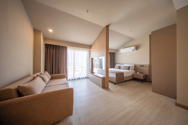 Junior suite, terras, gedeeltelijk uitzicht op zee | Woonruimte | Een 43-inch smart-tv met satellietzenders, Netflix en streamingdiensten