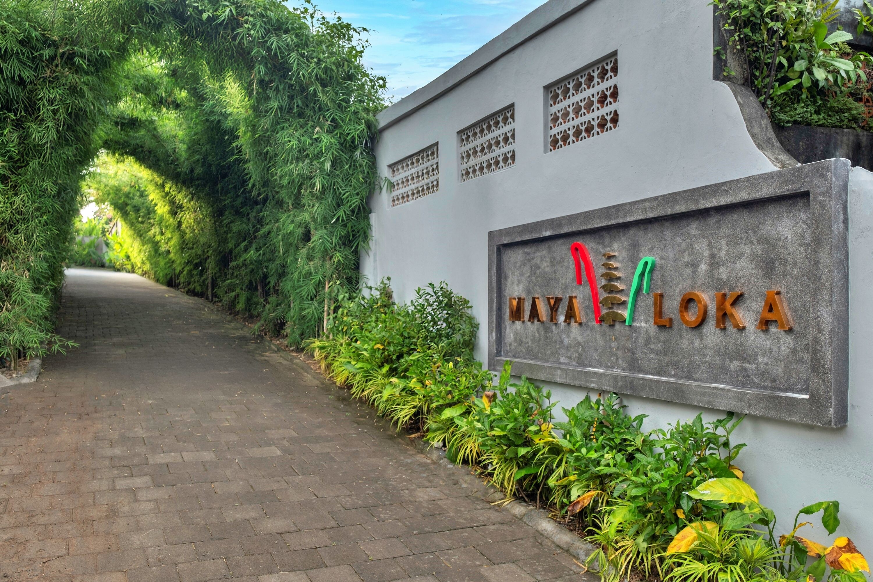 Un sendero que conduce a un edificio con un letrero que dice "MAYA LOKA".