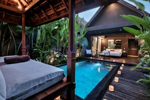 A bedroom with a large bed, a wooden ceiling, and a view of a pool area. - Mayaloka Villas Ubud (Ubud)