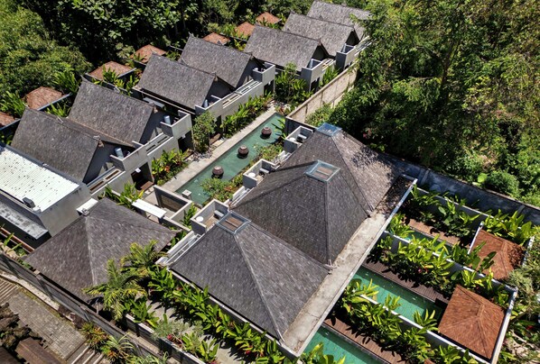 A resort with multiple bungalow-style buildings, a central pool area, and lush surrounding vegetation. - Mayaloka Villas Ubud (Ubud)