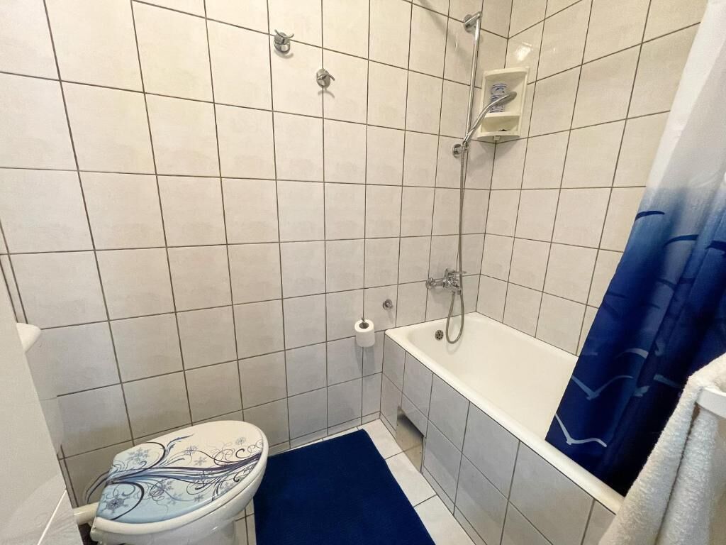 Une salle de bain avec des toilettes, une douche et une baignoire.