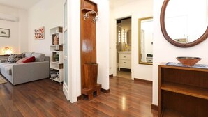 A living room with a sofa, a wooden cabinet, and a mirror.