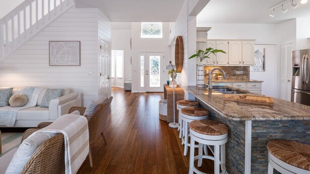 A spacious kitchen with a central island, white cabinetry, and a stainless steel refrigerator. - Bring Your Boat Heated Pool spa Dock Beach (Palm Coast)
