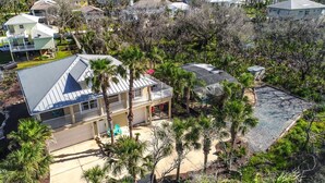 Una propiedad residencial con una casa de dos pisos, un patio cubierto y una piscina.