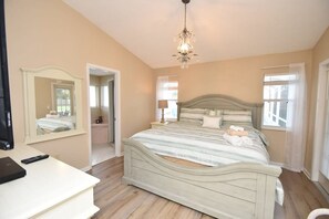 Cozy retreat with a large bed, mirror, and nightstand.
