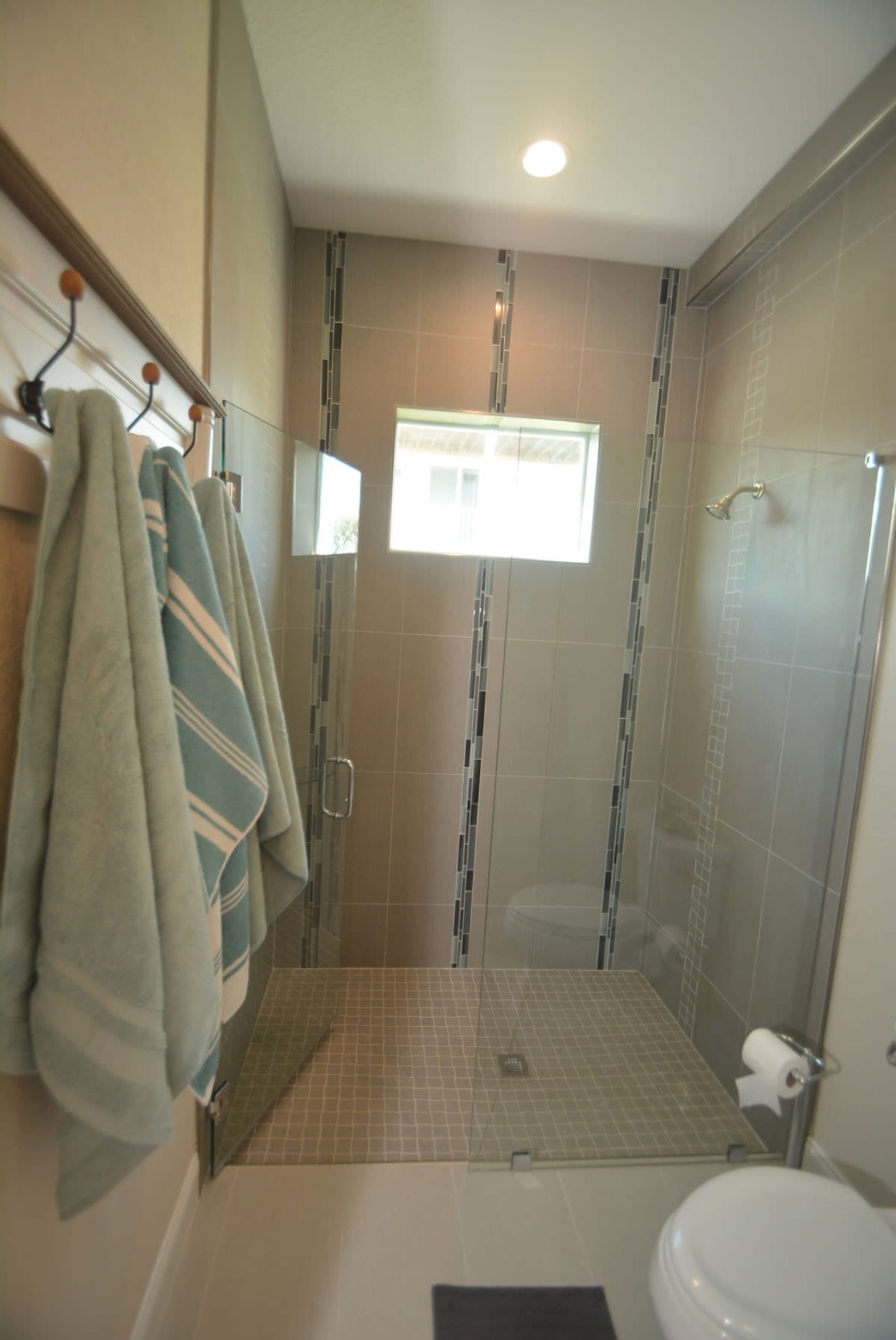 A bathroom with a shower, a toilet, and a towel rack.