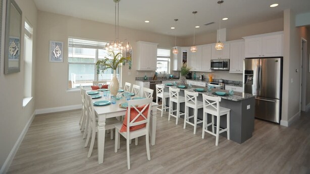 A modern kitchen with white cabinetry, stainless steel appliances, and a central island. - Beach Front 5 bed 4 Bath Luxury House Hot Tub Fenced Yard Pets Welcome (Palm Coast)