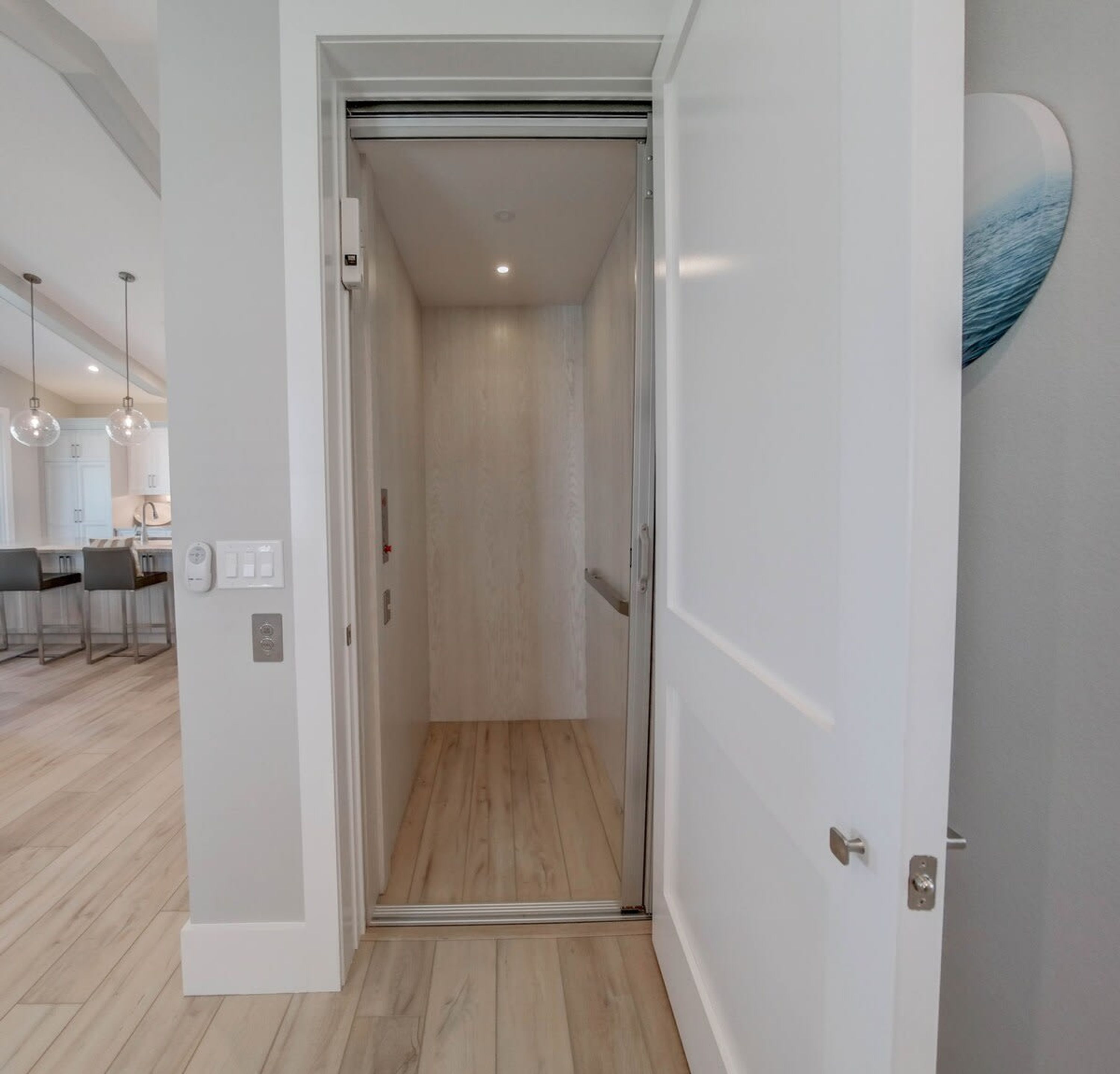 Un pasillo moderno y minimalista con suelo de madera y paredes blancas.