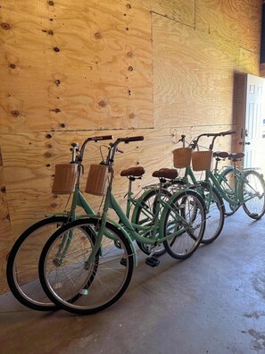Varias bicicletas están aparcadas junto a una pared de madera en un garaje.