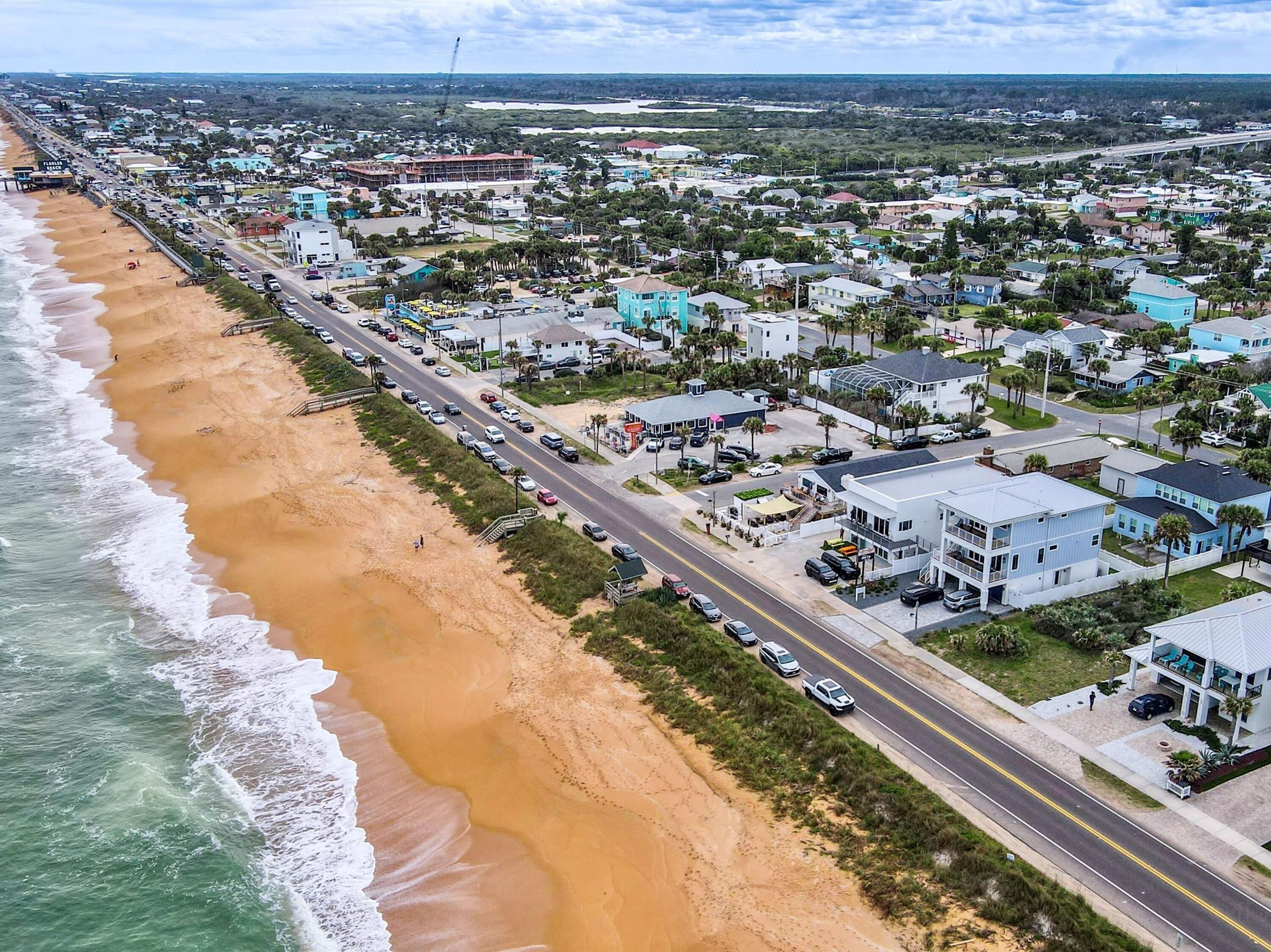 A coastal town with a beach, roads, and residential buildings.