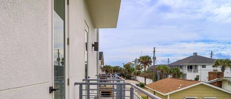 A residential building with a balcony, a small shed, and a clear sky.