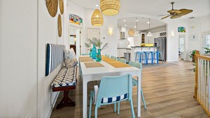 A spacious dining area with a long table, blue chairs, and woven pendant lights. - Perfect Beach House 2min Walk With Heated Pool and Hot Tub 4 bed 3 Bath With Pet Friendly (Palm Coast)