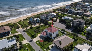 Zona residencial costera con casas, una playa y una flecha roja destacada señalando una vivienda en particular.
