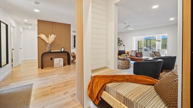 A modern interior with a reception desk, a sofa, and a dining area with a view.