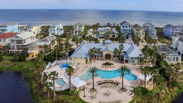 A resort with multiple buildings, a central pool, and a view of the ocean. - New Luxury Ocean Front 3 Bedroom 2 Bath Condo Sleeps 8 Cinnamon Beach Resort (Palm Coast)