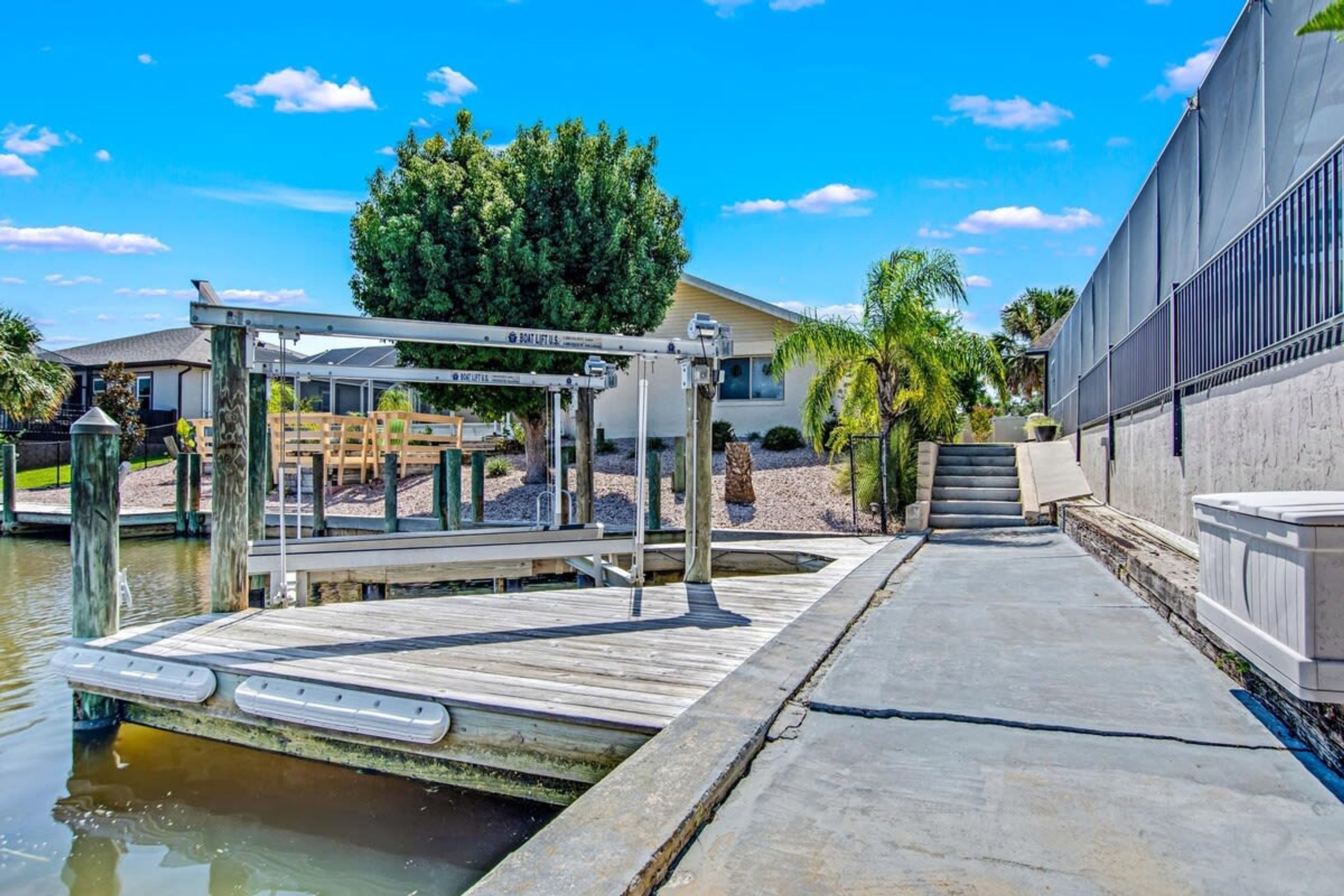 Un muelle con un elevador para barcos, una pasarela de hormigón y un edificio con un ventanal grande.