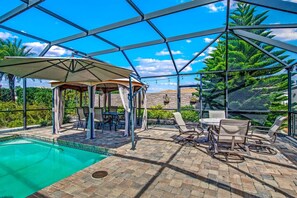 A covered outdoor area with a pool, lounge chairs, and a gazebo. - Saltwater Canal Home Heated Pool 3 2 2 Gorgeous Pets Welcome (Palm Coast)
