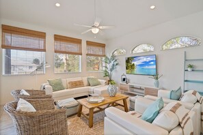 A modern living room with a sofa, coffee table, and wicker baskets. - Casa Coral- Heated Infinity Pool Canal Home (Palm Coast)