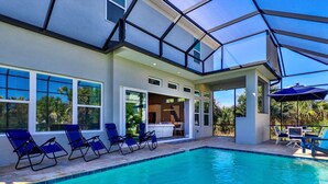 A modern house with a swimming pool, sun loungers, and a covered patio area. - Seabliss Steps to the Beach Pool Home 4 4 5 new (Palm Coast)