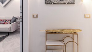 Un interior moderno con un retrato enmarco, un estante con marco dorado y un sofá estampado.
