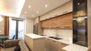 Een moderne keuken met een centraal eiland, inbouwmeubels en een kroonluchter.