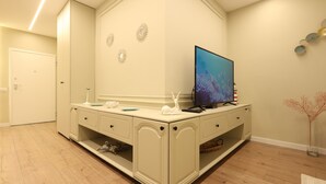 Un baño moderno con tocador, televisor y decoración en la pared.