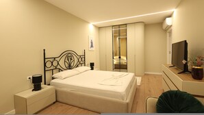 Un dormitorio con cama, mesita de noche, televisor y armario.