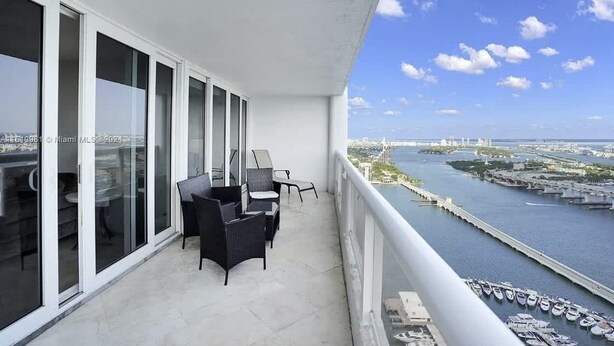 A balcony with a view of a marina and city skyline. - High Rise | Premium Amenities | BayView | StayCozy (Miami)