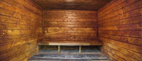 A wooden sauna with a bench and a small window.