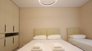 Hotellihuone, jossa on suuri sänky, kaksi yöpöytää ja vaatekaappi.