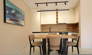 Une cuisine moderne dotée d’un plan de travail en bois, d’un évier encastré et d’un coin repas avec une table et des chaises.