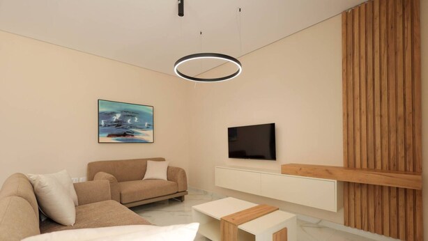 Una sala de estar moderna con un sofá, una mesa de centro, un televisor y una obra de arte en la pared.