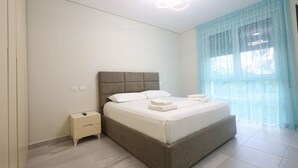 Une chambre à coucher avec un lit, une table de chevet et une fenêtre avec des rideaux.