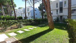 Une cour avec une pelouse, des marches en pierre et des arbres.