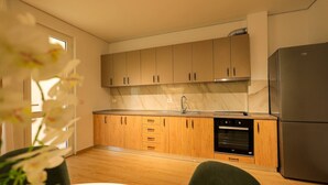 Une cuisine moderne avec des meubles en bois, un réfrigérateur en acier inoxydable et un four encastré.