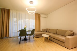 A modern living room with a beige sofa, a small round table, two chairs, and a pendant light. - Sanpietro Vacation Apartment 038 (Ishëm)
