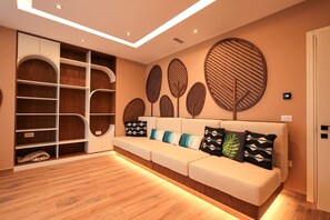A modern living room with a sofa, built-in shelves, and decorative wall panels. - Sanpietro Elite Signature Villa (Ishëm)