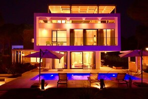 A modern two-story house with a swimming pool, outdoor seating, and large windows. - Sanpietro Elite Signature Villa (Ishëm)