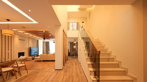 Un vaste espace de vie doté d’un plancher en bois, d’un escalier et d’un aménagement intérieur moderne.