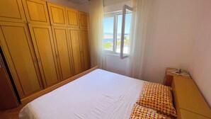 Un dormitorio con una cama grande, un armario y un ventanal con vistas.