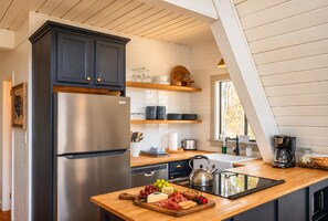 Une cuisine moderne dotée d’un réfrigérateur en acier inoxydable, de plans de travail en bois et d’une variété d’aliments exposés sur le comptoir.